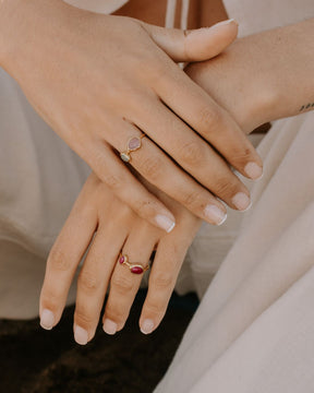 Modelo con dos variedades del anillo Diana de Isla Vurma; en una mano lleva el diseño elaborado con Calcedonia en rosa y azul y, en la otra mano, el anillo Diana con piedra Rubí.
