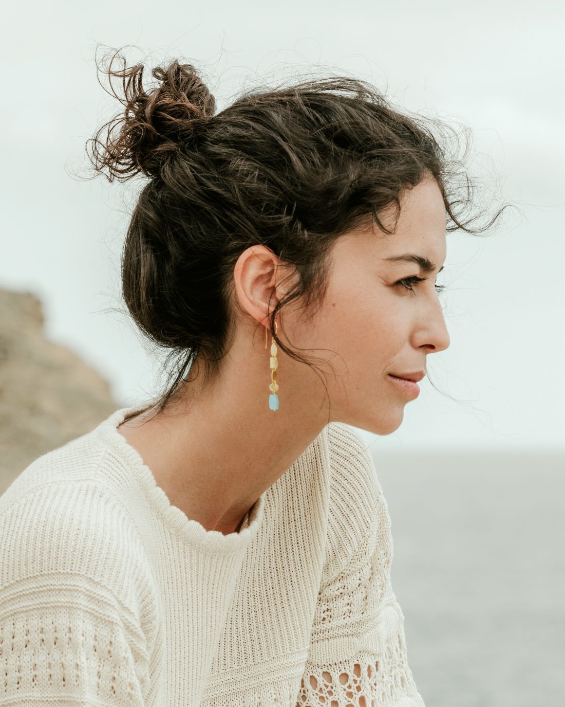 Pendiente dorado de estilo orgánico, formado por pequeñas piezas geométricas martilladas y una piedra semipreciosa Aqua Calcedonia al final