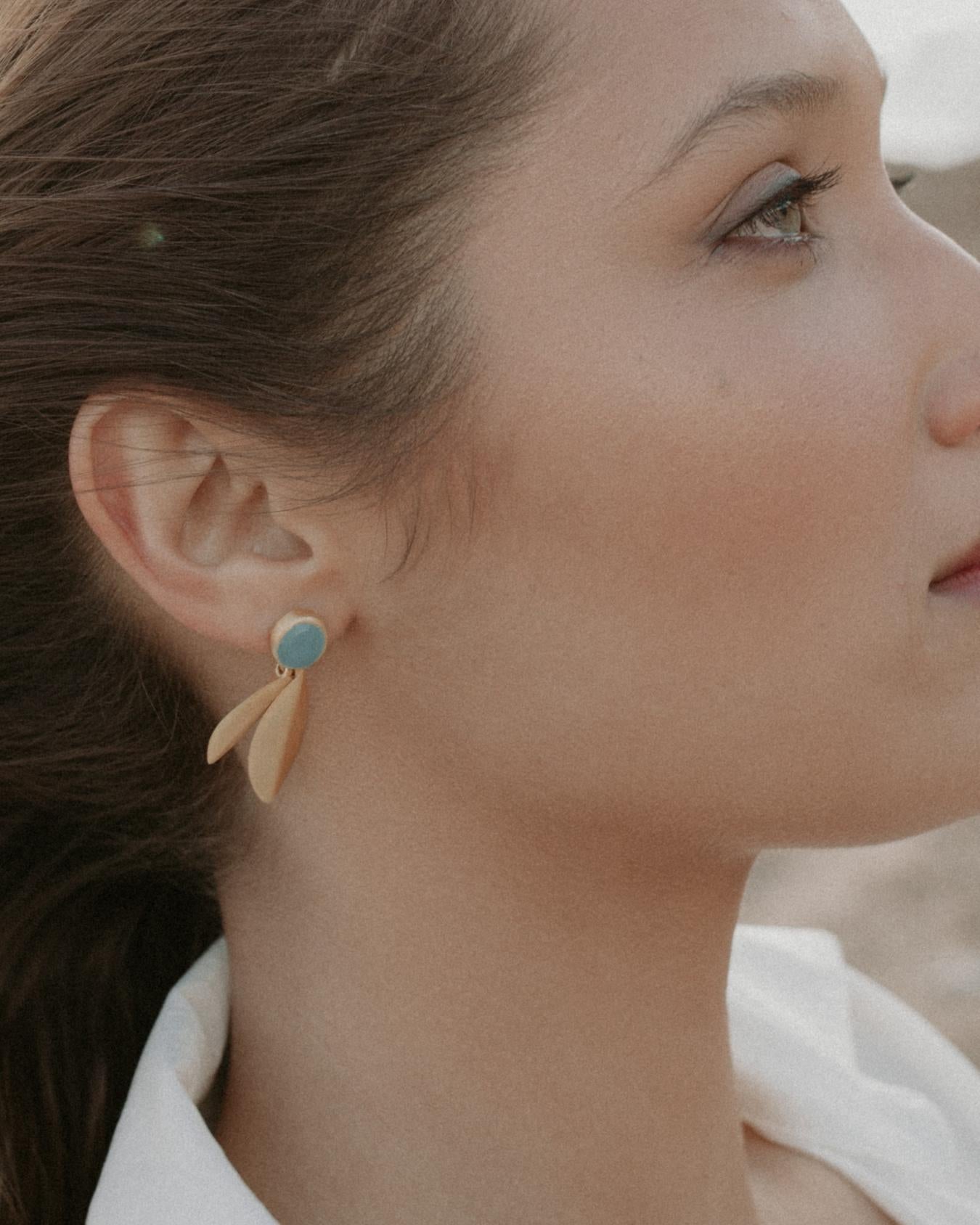 Modelo de perfil con pendientes de latón bañado en oro y piedra Aqua Calcedonia