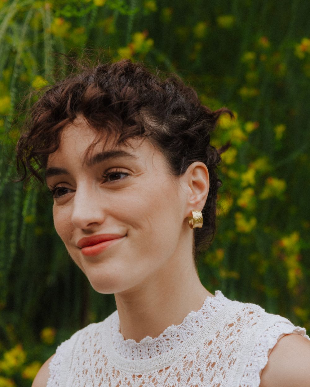 Modelo con los pendientes bañados en oro de 18 quilates abiertos y cierre mariposa de Isla Vurma