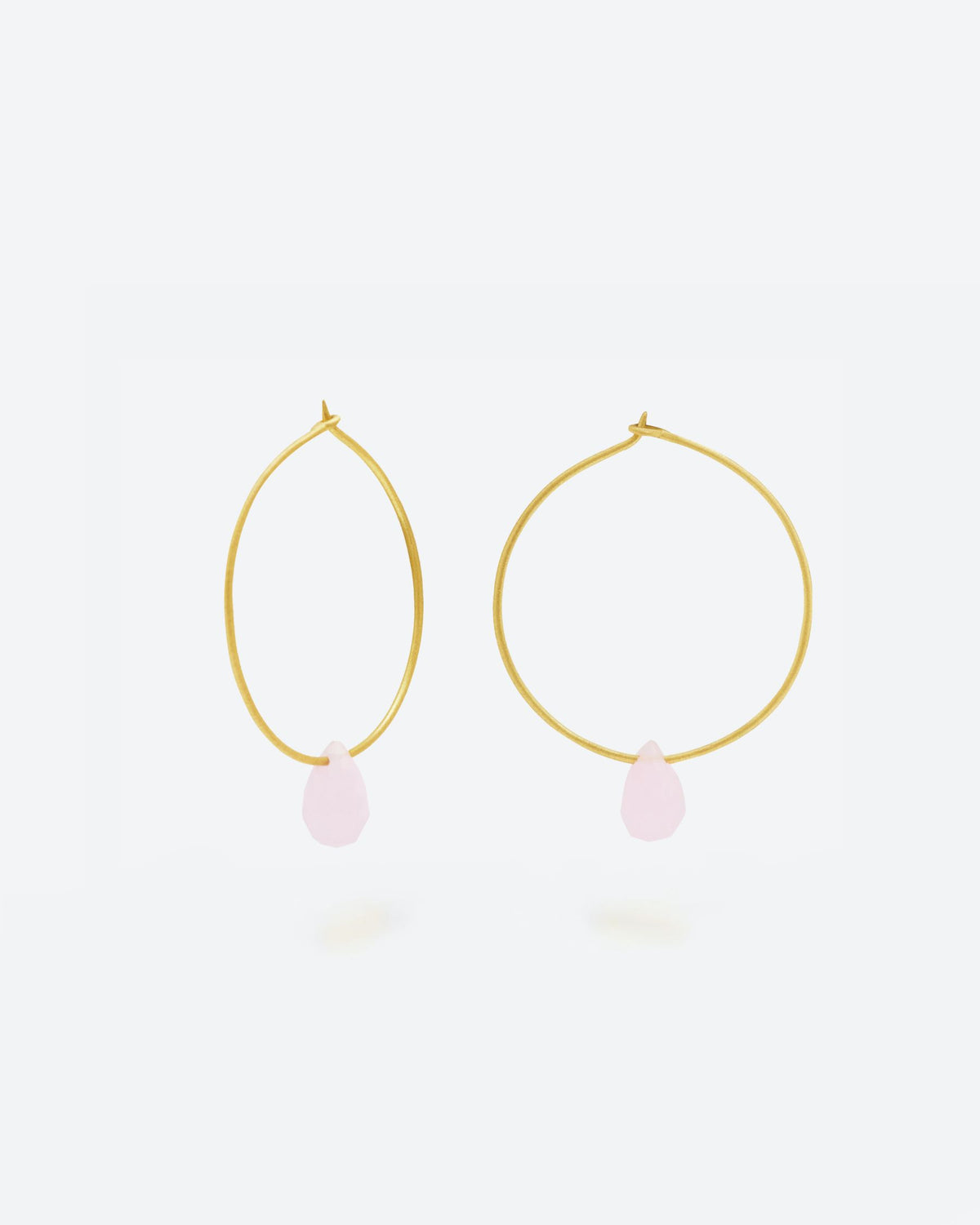 Primer plano de los pendientes en forma de Aro bañado en oro de 18 quilates con piedra semipreciosa Rosa Calcedonia en forma de gota