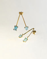 Pendientes colgantes artesanales de latón dorado con piedras azul aguamarina. Diseño moderno y minimalista, joyería elegante y ligera para mujer.