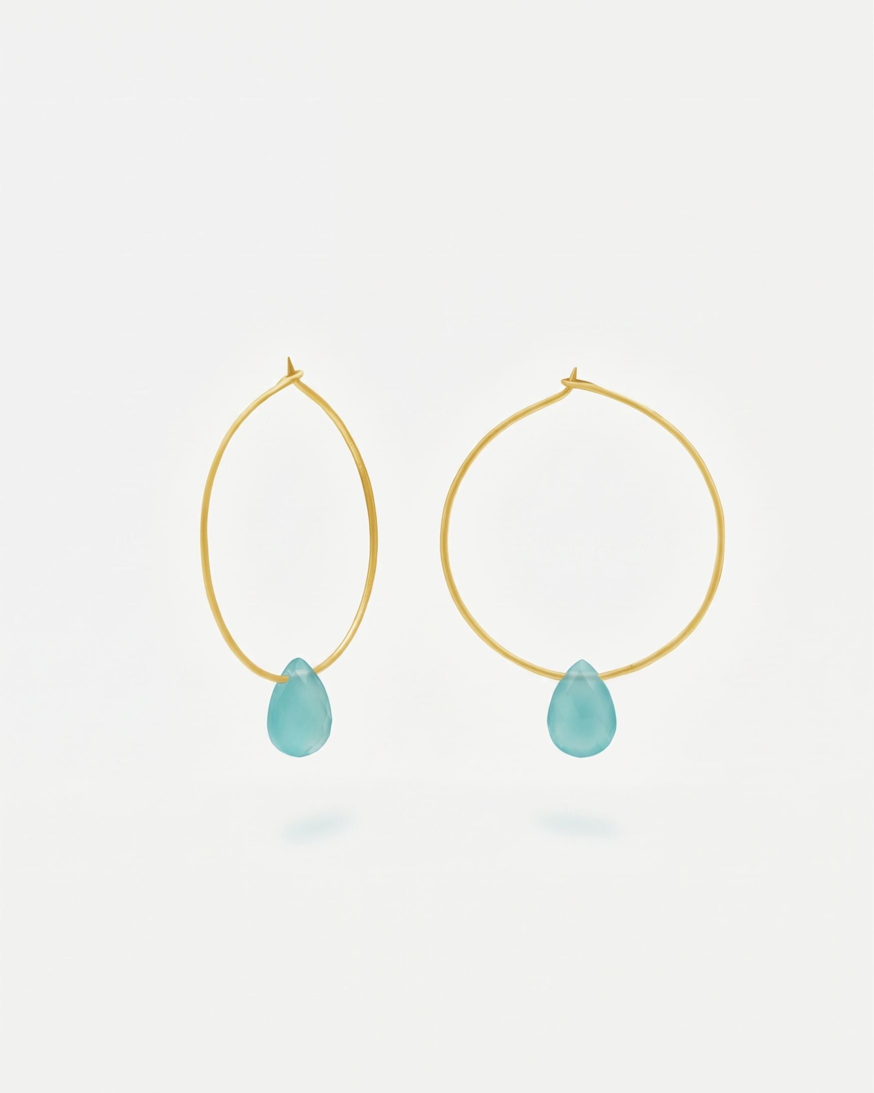 Primer plano de los pendientes en forma de Aro bañado en oro de 18 quilates con piedra semipreciosa Aqua Calcedonia en forma de gota
