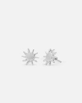 Primer plano de los pendientes en forma de sol bañados en plata de ley 925 y cierre mariposa de Isla Vurma