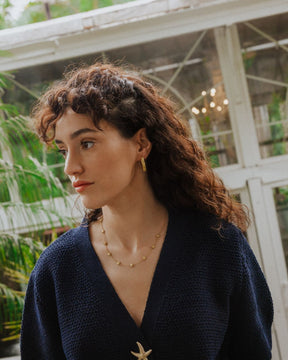 Modelo llevando los pendientes gruesos circulares irregulares bañados en oro de 18k de Isla Vurma