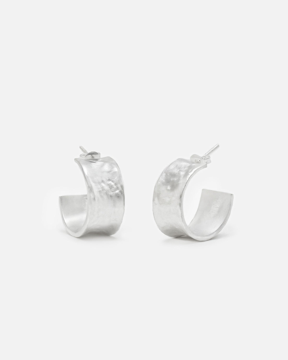 Primer plano de los pendientes bañados en plata 925 ondulados abiertos y cierre mariposa de Isla Vurma