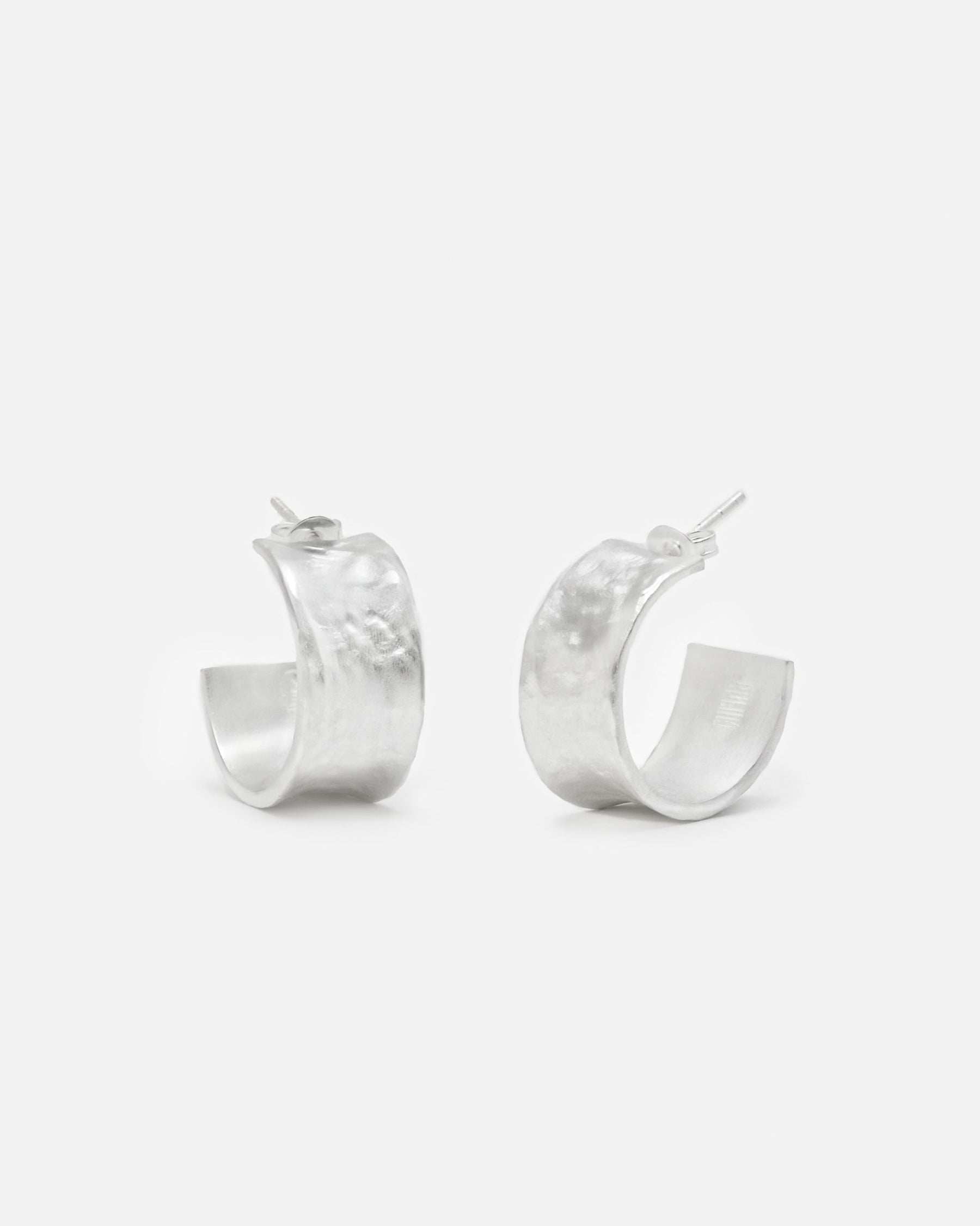 Primer plano de los pendientes bañados en plata 925 ondulados abiertos y cierre mariposa de Isla Vurma