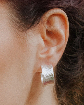 Primer plano de la modelo con los pendientes bañados en plata 925 ondulados abiertos y cierre mariposa de Isla Vurma