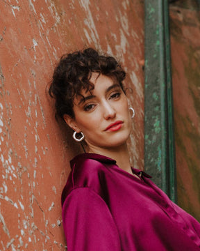 Modelo mirando al frente llevando los pendientes gruesos circulares irregulares bañados en plata 925 de Isla Vurma