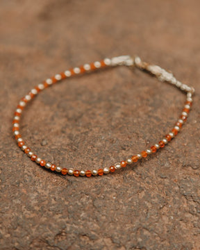 Primer plano una pulsera con cuentas facetadas de piedra semipreciosa en Cornalina y bañadas en Oro de 18 quilates