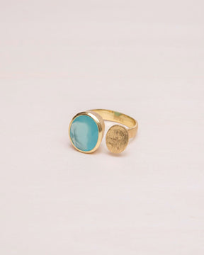 Primer plano del anillo abierto bañado en oro de 18k con piedra semipreciosa en forma circular en Aqua Calcedonia de Isla Vurma