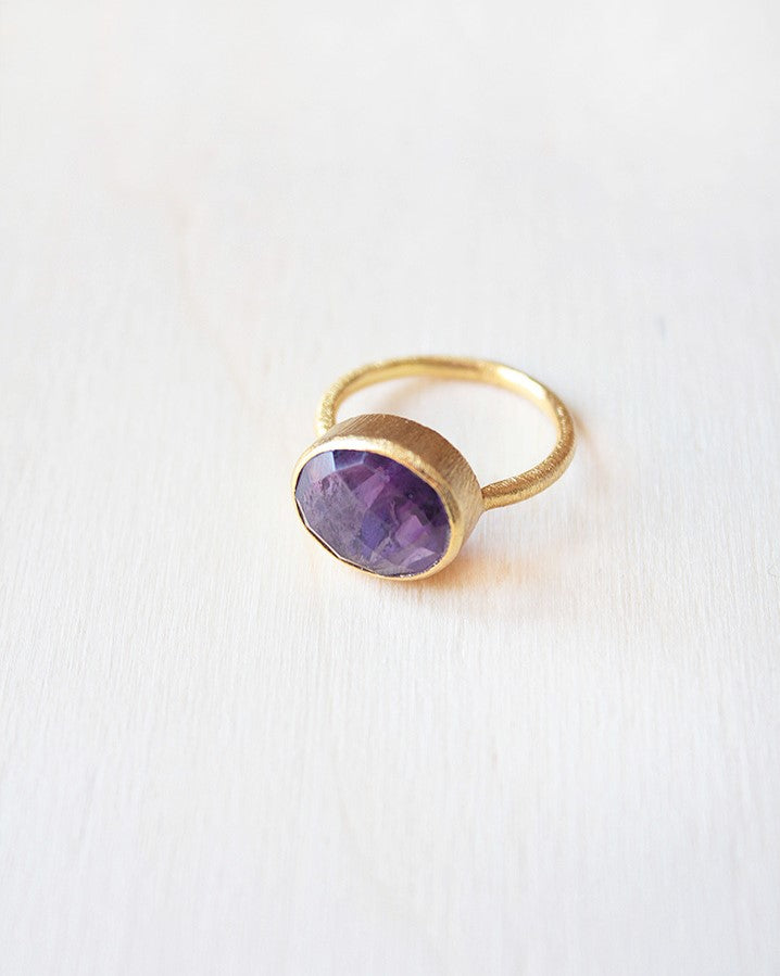 Primer plano del anillo circular bañado en oro de 18k con piedra semipreciosa en Amatista de Isla Vurma