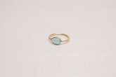 Primer plano del anillo bañado en oro de 18 quilates con piedra semipreciosa en forma de gota en Aqua Calcedonia de Isla Vurma
