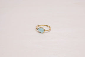 Primer plano del anillo bañado en oro de 18 quilates con piedra semipreciosa en forma de gota en Aqua Calcedonia de Isla Vurma