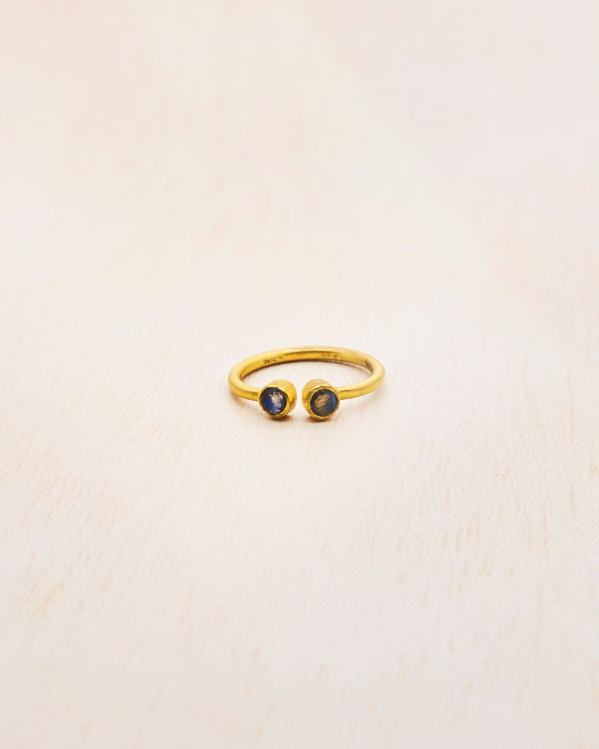 Anillo de latón bañado en Oro de 18k de diseño abierto con dos pequeñas piedras semipreciosas en Labradorita en los extremos en forma redondeada