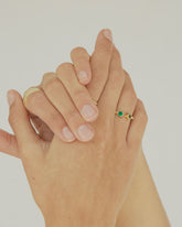 Primer plano de las manos de la modelo con el anillo de latón bañado en Oro de 18k de diseño abierto con dos pequeñas piedras semipreciosas en Amatista Verde y Ónix Verde en los extremos en forma redondeada