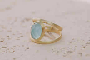 Primer plano del anillo bañado en Oro de 18k con piedra semipreciosa Aqua Calcedonia tallada en forma ovalada