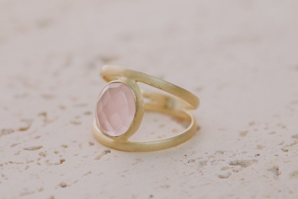 Primer plano del anillo bañado en oro de 18k con piedra semipreciosa Cuarzo Rosa tallada en forma ovalada