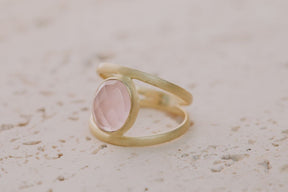 Primer plano del anillo bañado en oro de 18k con piedra semipreciosa Cuarzo Rosa tallada en forma ovalada