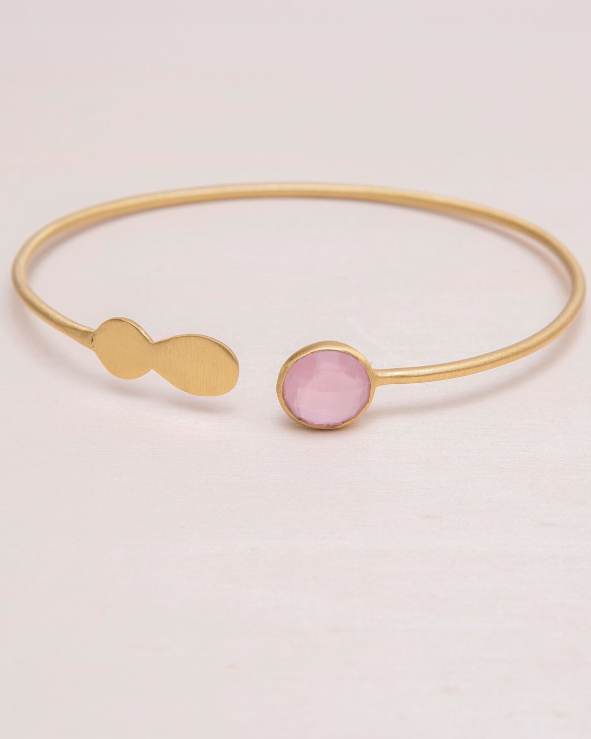 Primer plano del brazalete de latón bañado en oro de 18 quilates con una piedra semipreciosa en Cuarzo Rosa en uno de los extremos