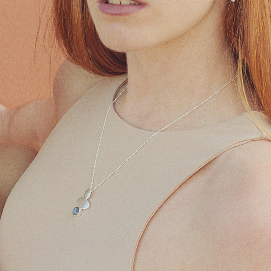 Modelo con collar bañado en Plata con pieza geométrica y piedra semipreciosa Labradorite
