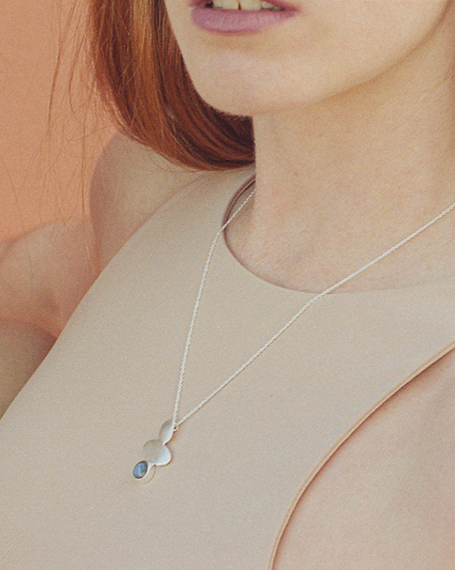 Modelo con collar bañado en Plata con pieza geométrica y piedra semipreciosa Labradorite