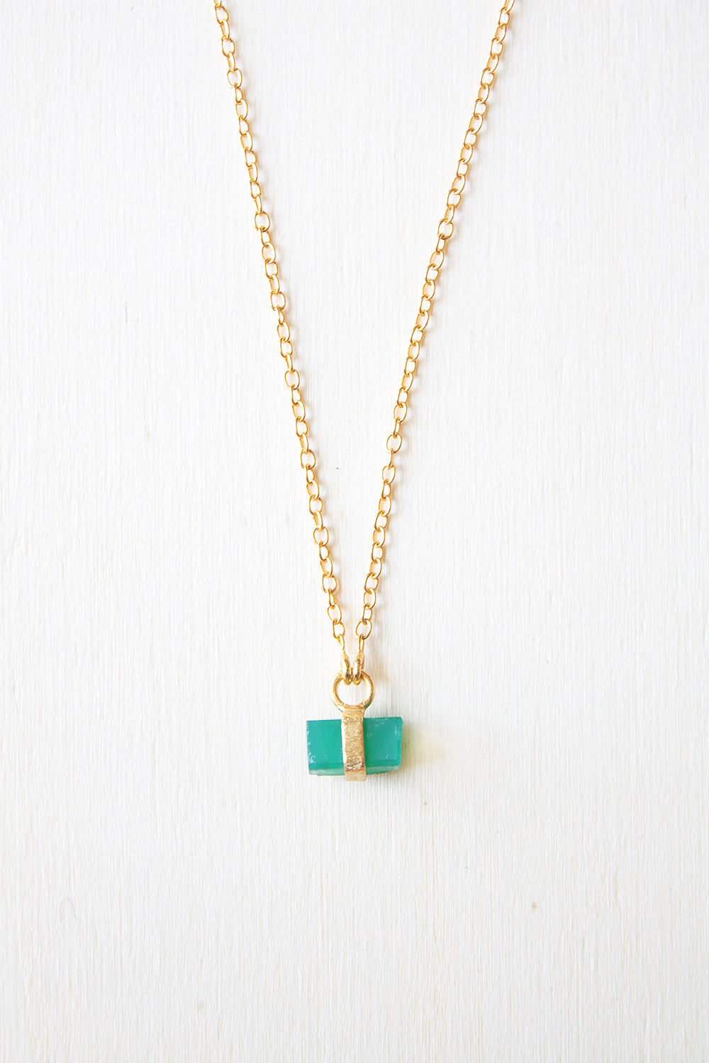 Primer plano del collar bañado en oro de 18k, con piedra semipreciosa rectangular de Onix Verde de Isla Vurma