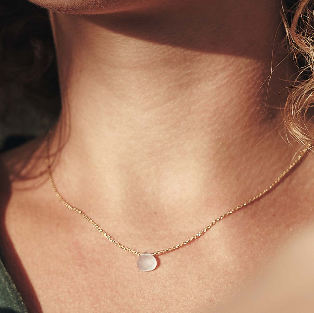 Modelo con collar bañado en oro de 18 quilates con piedra tallada en Cuarzo de Isla Vurma