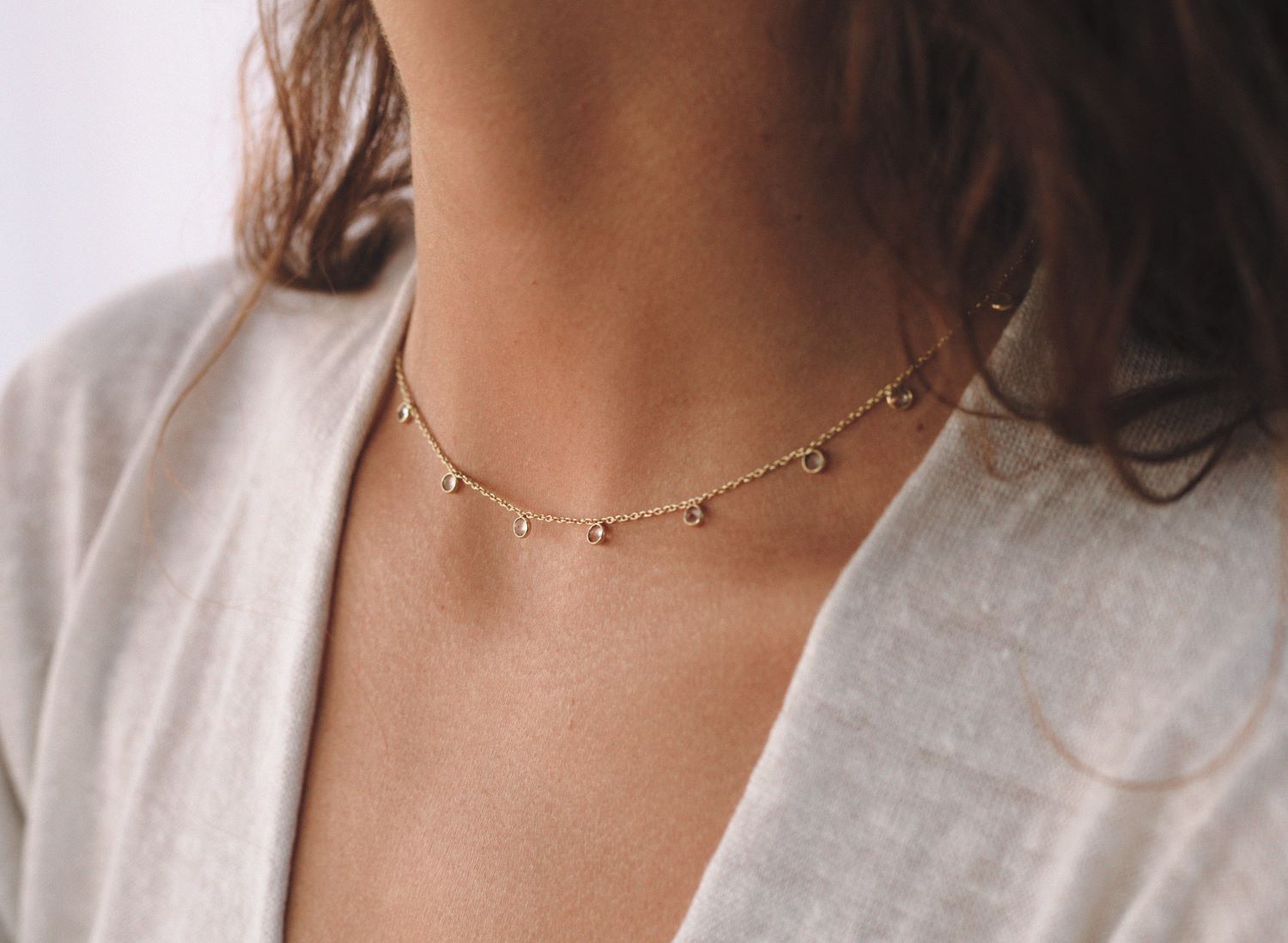 Primer plano de modelo con camiseta blanca y collar bañado en oro de 18 quilates con piedras semipreciosas en Aqua Calcedonia de Isla Vurma