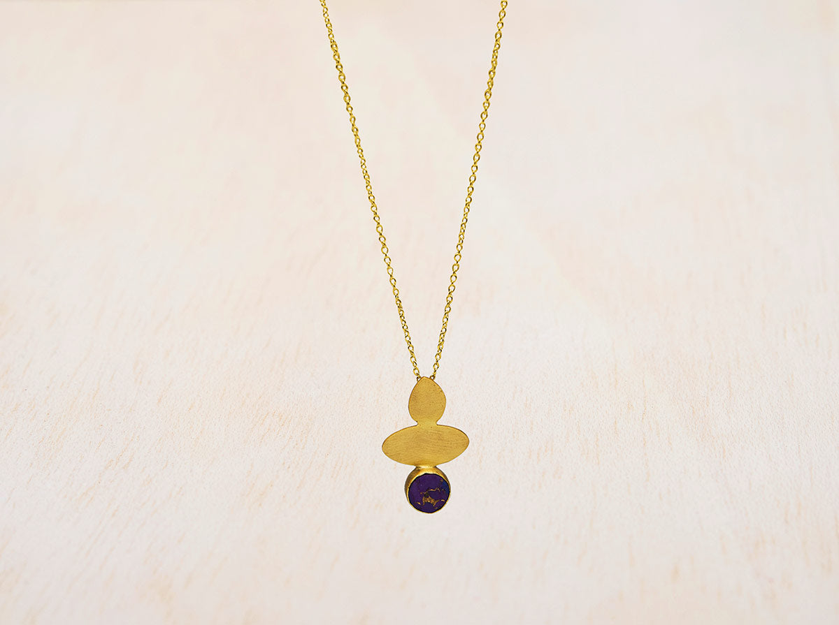 Primer plano de collar geométrico y piedra semipreciosa circular Amatista sobre fondo blanco de Isla Vurma