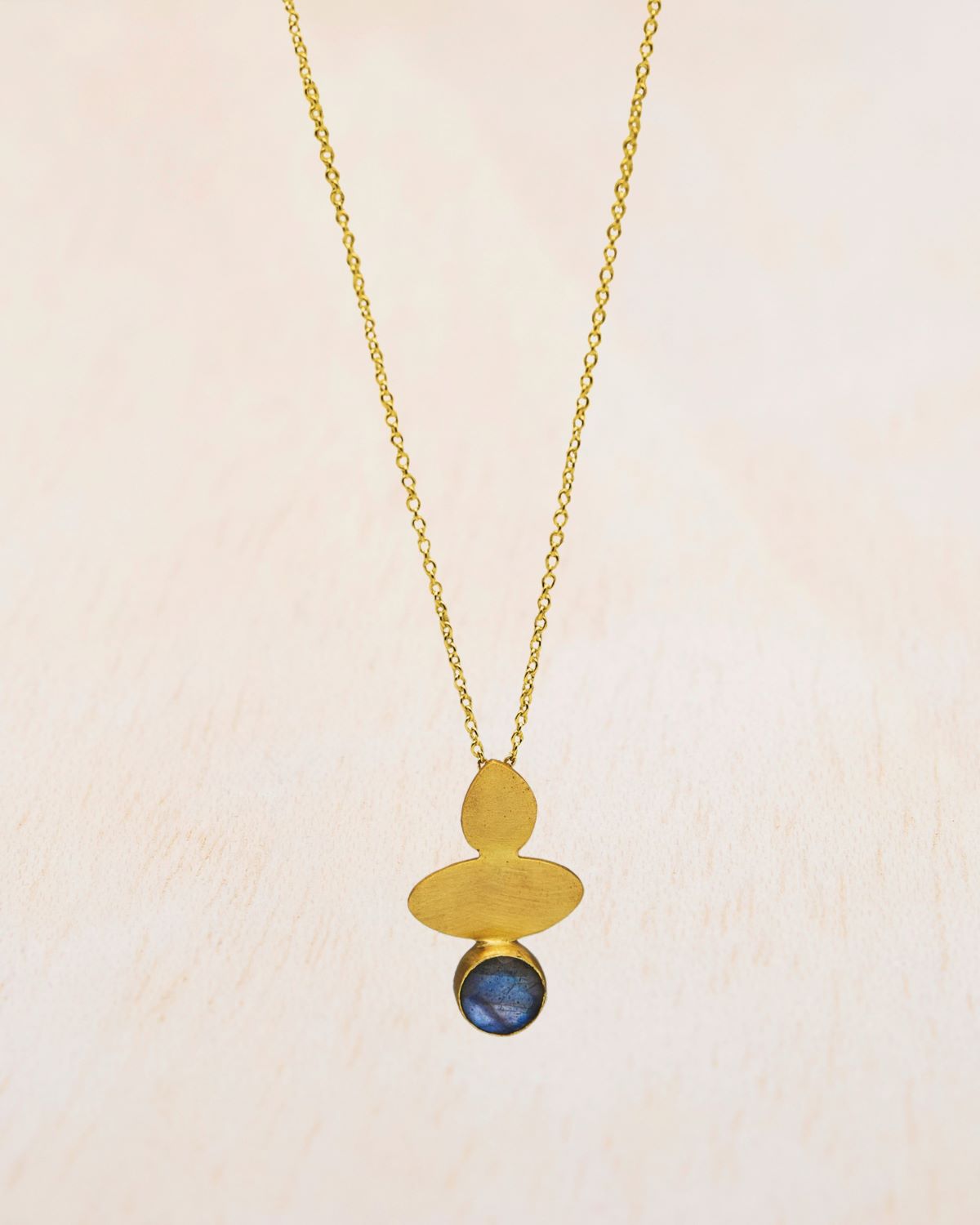 Primer plano del collar geométrico bañado en oro de 18k y con piedra semipreciosa Labradorite de Isla Vurma