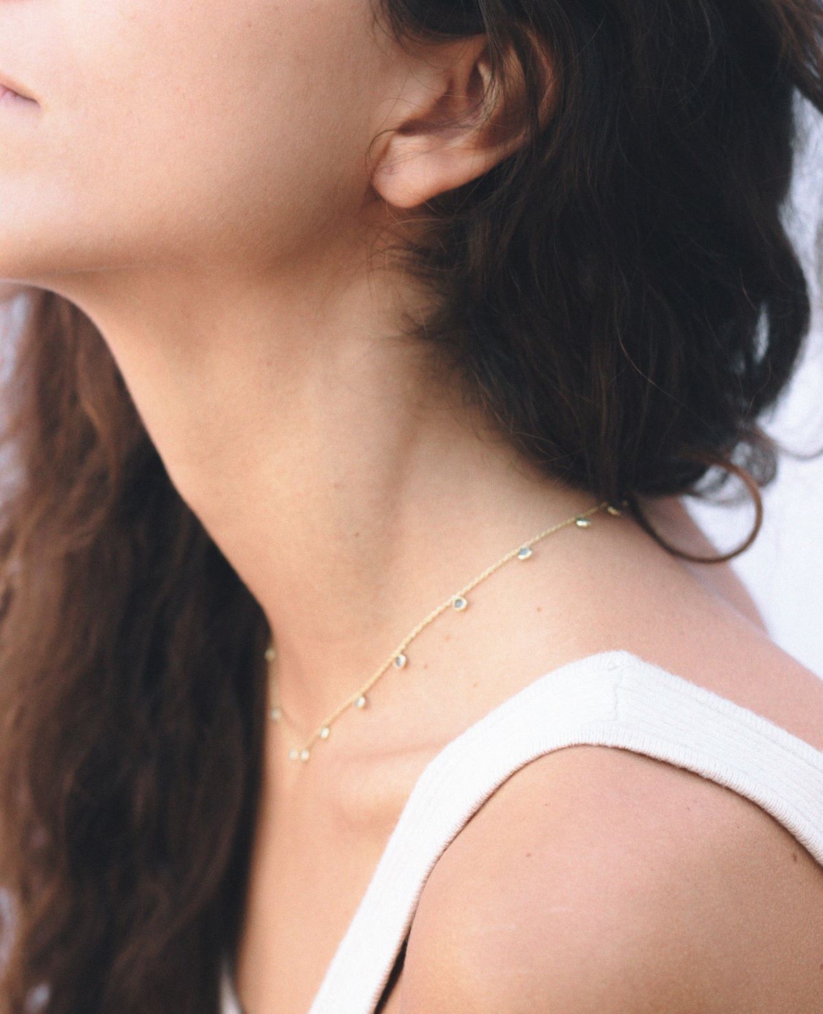 Modelo de lado con el collar bañado en oro de 18k con la piedra semipreciosa Aqua Calcedonia de Isla Vurma