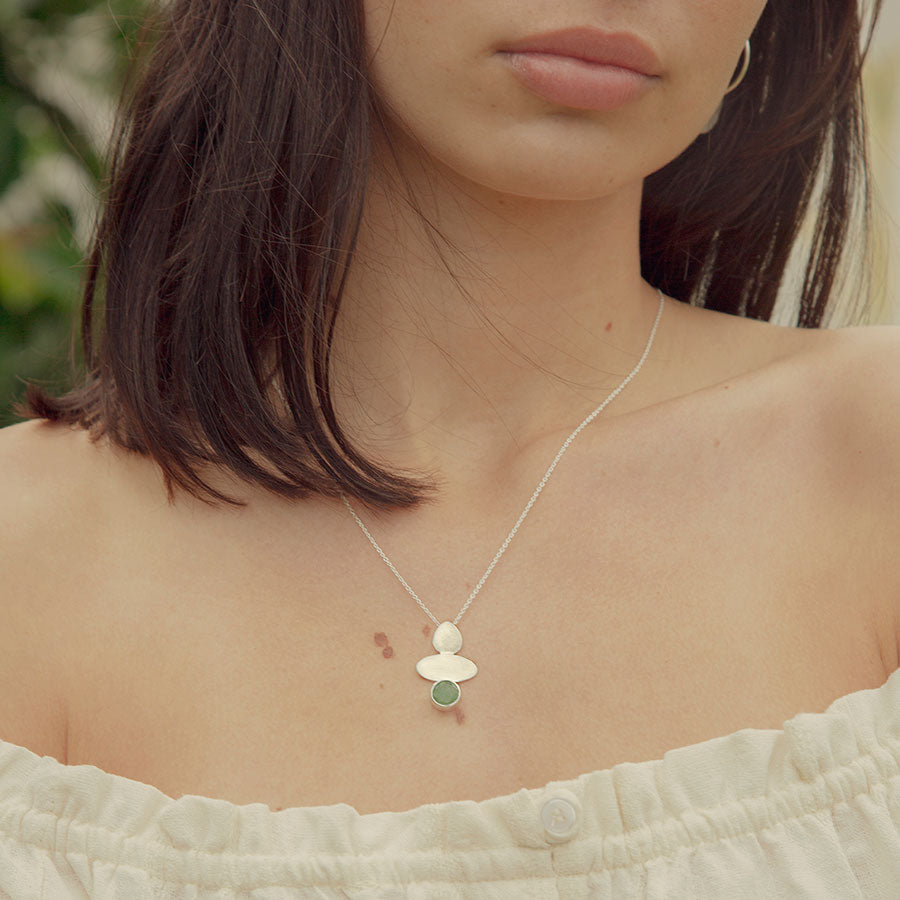 Modelo con collar plateado con forma geométrica y piedra semipreciosa Aventurina Verde de Isla Vurma