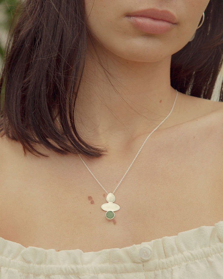 Modelo con collar plateado con forma geométrica y piedra semipreciosa Aventurina Verde de Isla Vurma