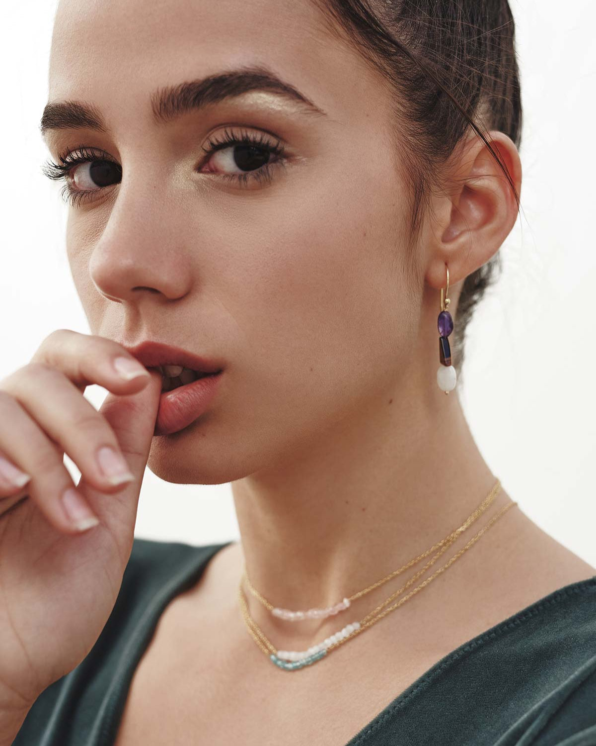 Modelo con conjunto de pendientes asimétricos y collares, todas las piezas elaboradas con piedras naturales