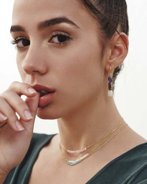 Modelo con conjunto de pendientes asimétricos y collares, todas las piezas elaboradas con piedras naturales