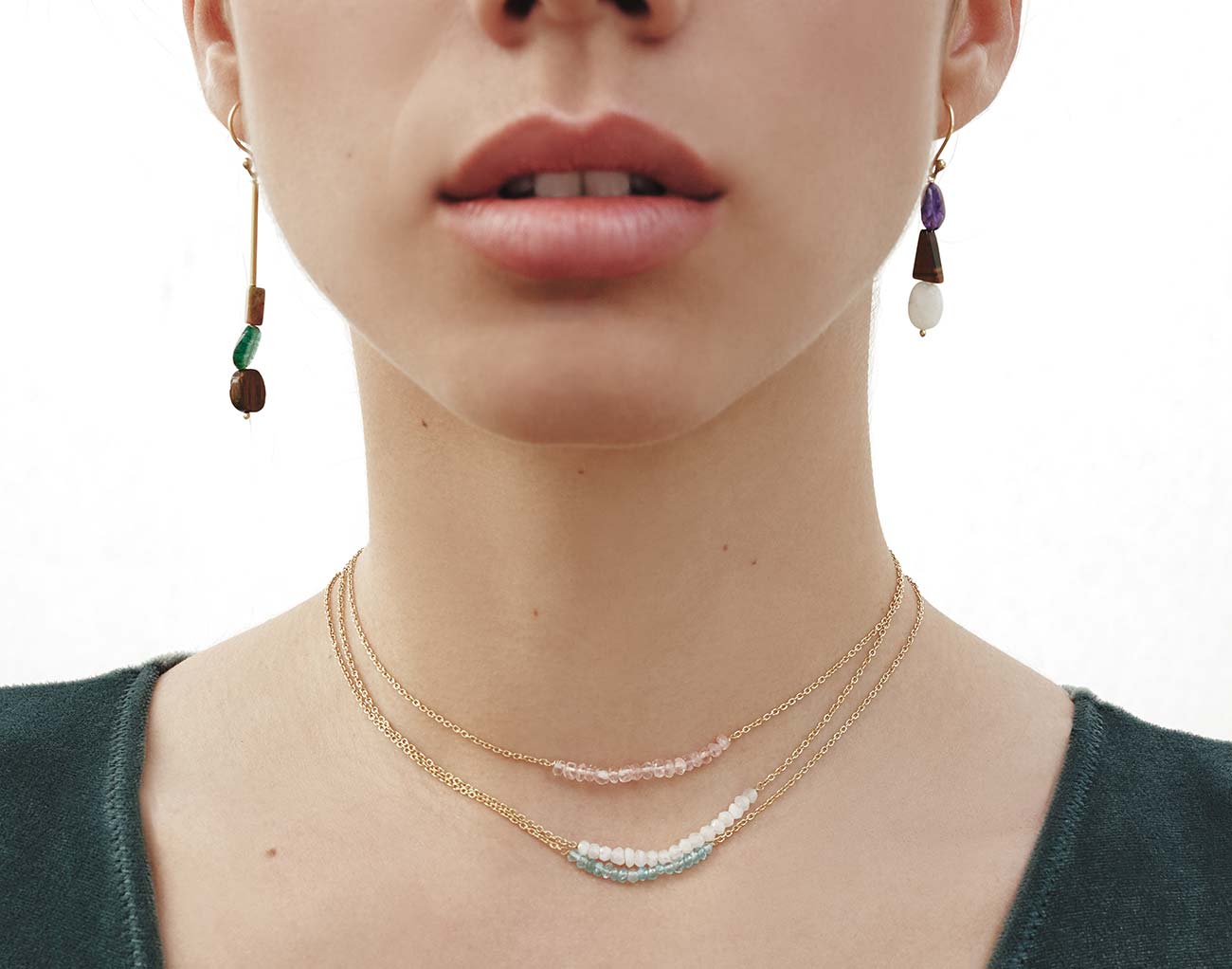 Pendientes asimétricos con ojo de tigre, amatista, jade y piedra de luna. Además lleva 3 collares, elaborados con cuarzo rosa, aqua calcedonia y piedra de luna