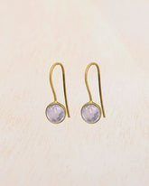 Primer plano de los pendientes con piedra semipreciosa Cuarzo Rosa entallada en forma redonda de Isla Vurma