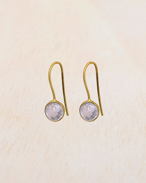 Primer plano de los pendientes con piedra semipreciosa Cuarzo Rosa entallada en forma redonda de Isla Vurma