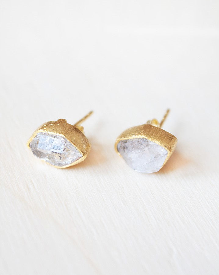 Primer plano de los pendientes bañados en oro de 18 quilates con piedra semipreciosa en Cuarzo Herkimer y cierre de botón de Isla Vurma