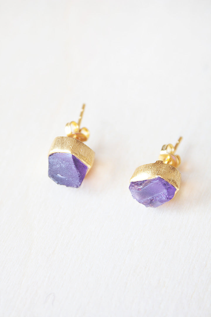 Primer plano de los pendientes bañados en oro de 18 quilates con piedra semipreciosa en Amatista y cierre de botón de Isla Vurma