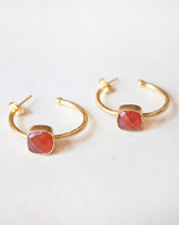 Primer plano de los pendientes bañados en Oro de 18 quilates con piedra semipreciosa cuadrada en Cornalina de Isla Vurma