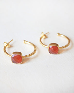 Primer plano de los pendientes bañados en Oro de 18 quilates con piedra semipreciosa cuadrada en Cornalina de Isla Vurma