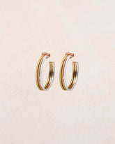 Aros tricolor de tamaño mediano con baño en oro 18k, oro rosa y plata 925 sobre fondo beige claro