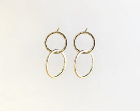 Primer plano de los pendientes bañados en oro de 18k compuesto por dos piezas circulares de Isla Vurma