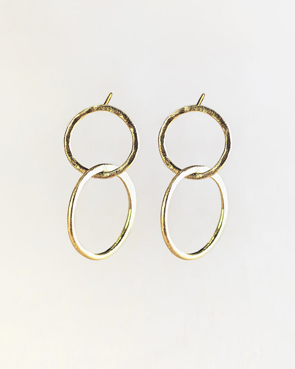 Primer plano de los pendientes bañados en oro de 18k compuesto por dos piezas circulares de Isla Vurma