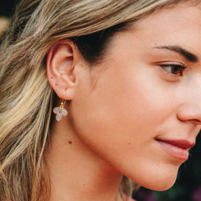 Modelo con pendientes en forma de pétalo con piedra semipreciosa en Piedra Luna Melocotón incrustada y cierre de gancho abierto de Isla Vurma