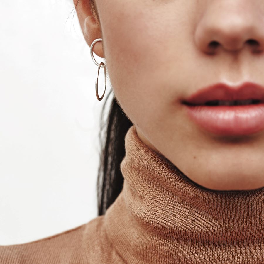 Modelo con pendientes de doble circulo plateados de Isla Vurma