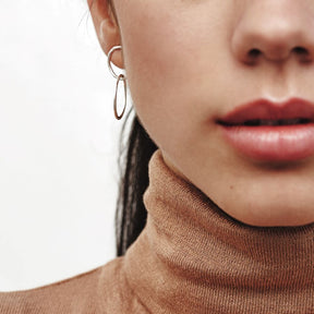 Modelo con pendientes de doble circulo plateados de Isla Vurma