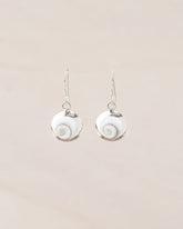 Primer plano de los pendientes pequeños artesanales de piedra de Santa Lucía montados en plata de ley 925 con diseño en espiral sobre fondo beige claro de Isla Vurma